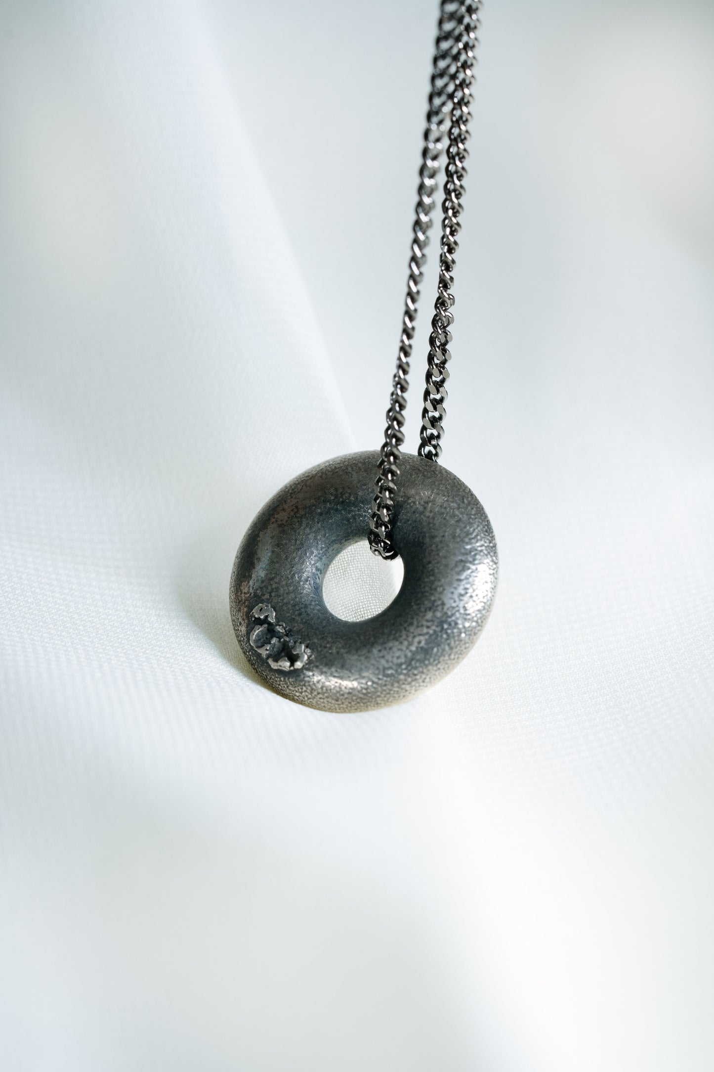 Sterling Silver Zen Doughnut Pendant hung on a Black 925 Silver Chain