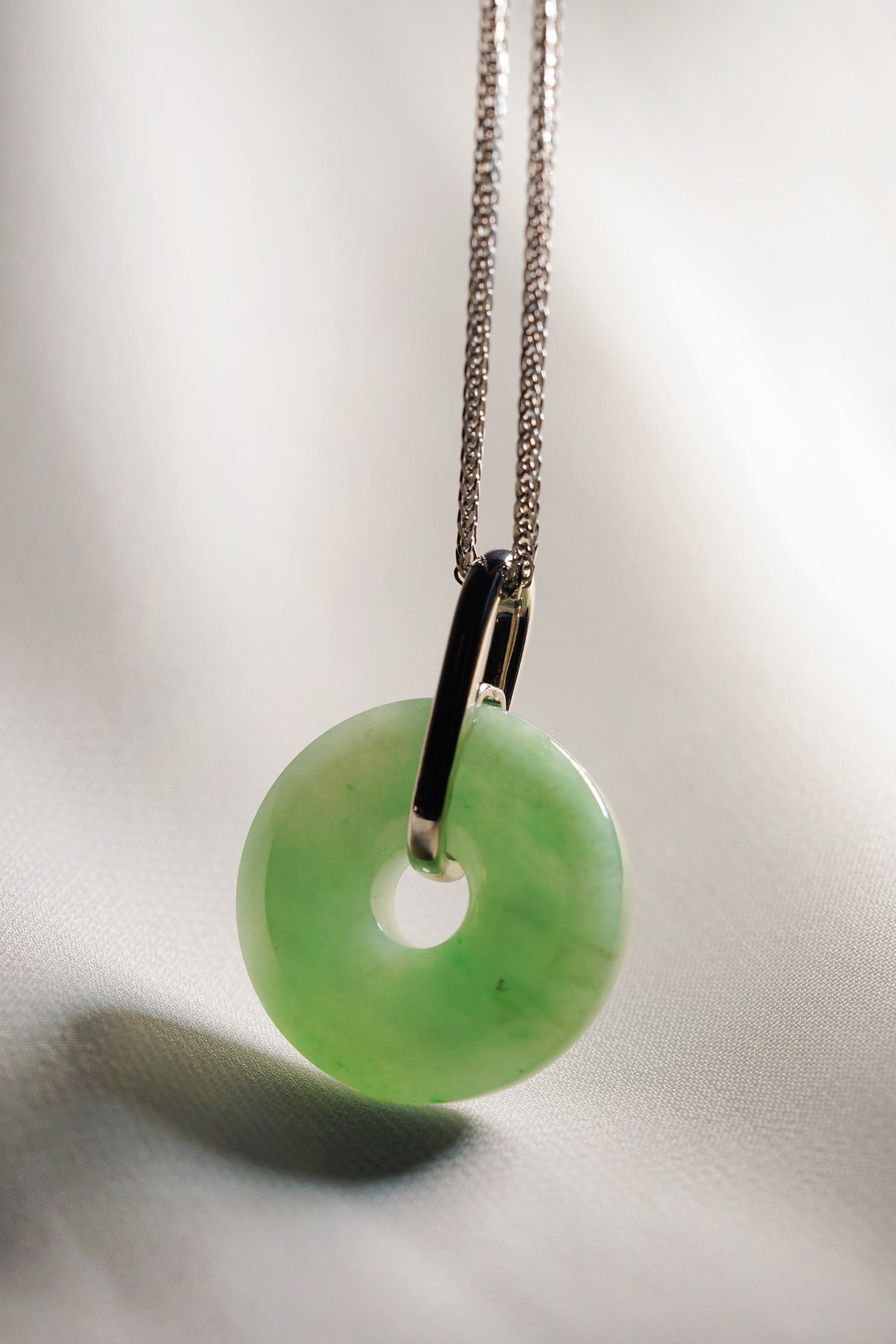 Pale Green Jadeite Zen Doughnut Pendant with Light Green patches added with a Platinum Loop hung on a 925 Silver Chain