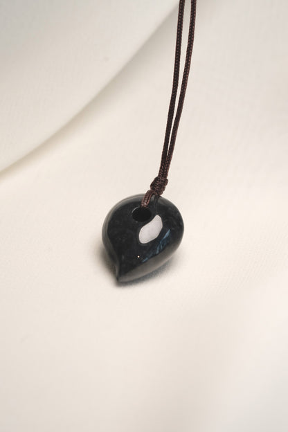 Black Jadeite Magatama Pendant with White patches hangs on a String