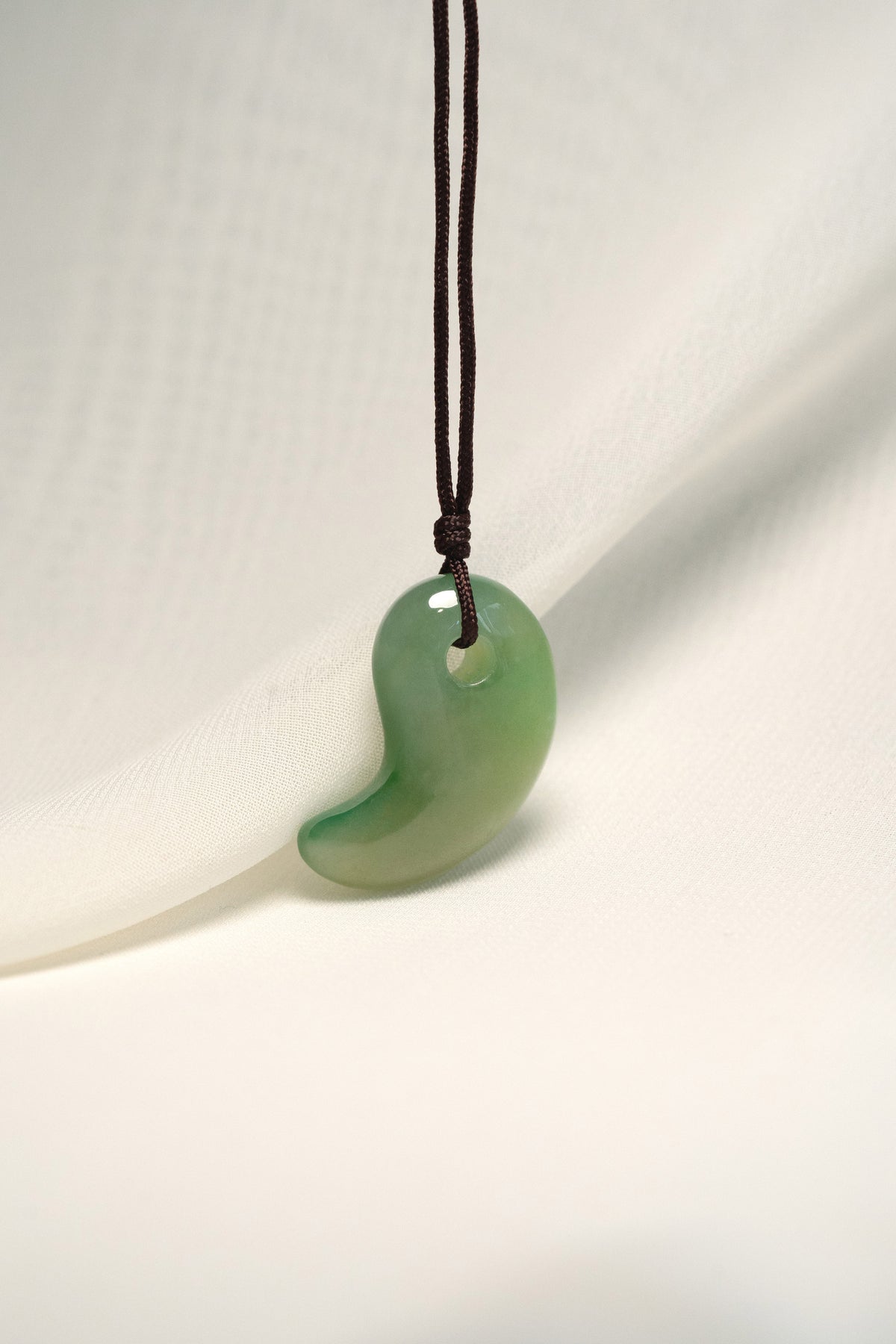 Medium Green Jadeite Magatama Pendant hangs on a String