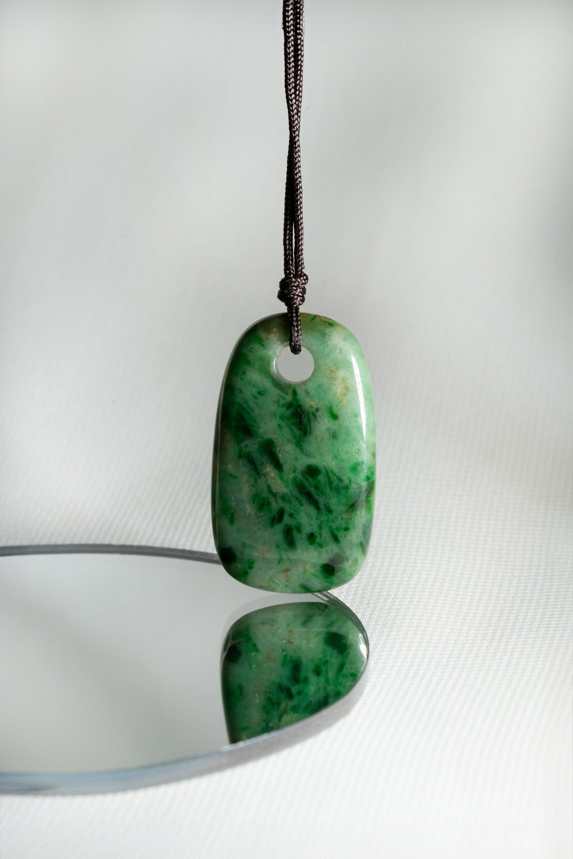 Pale Green Oval Jadeite Tag with Bright and Intense Green Patches