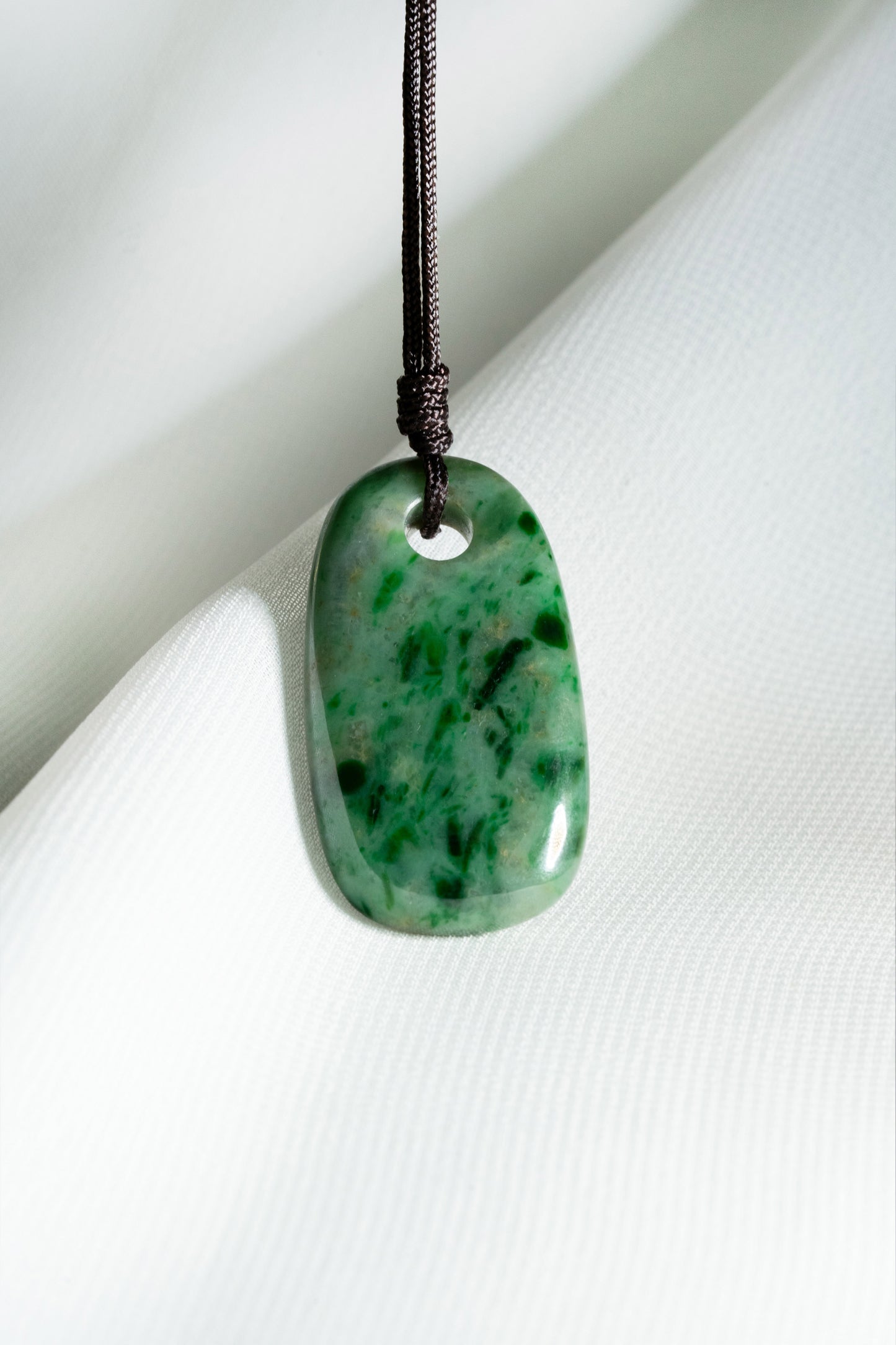 Pale Green Oval Jadeite Tag with Bright and Intense Green Patches