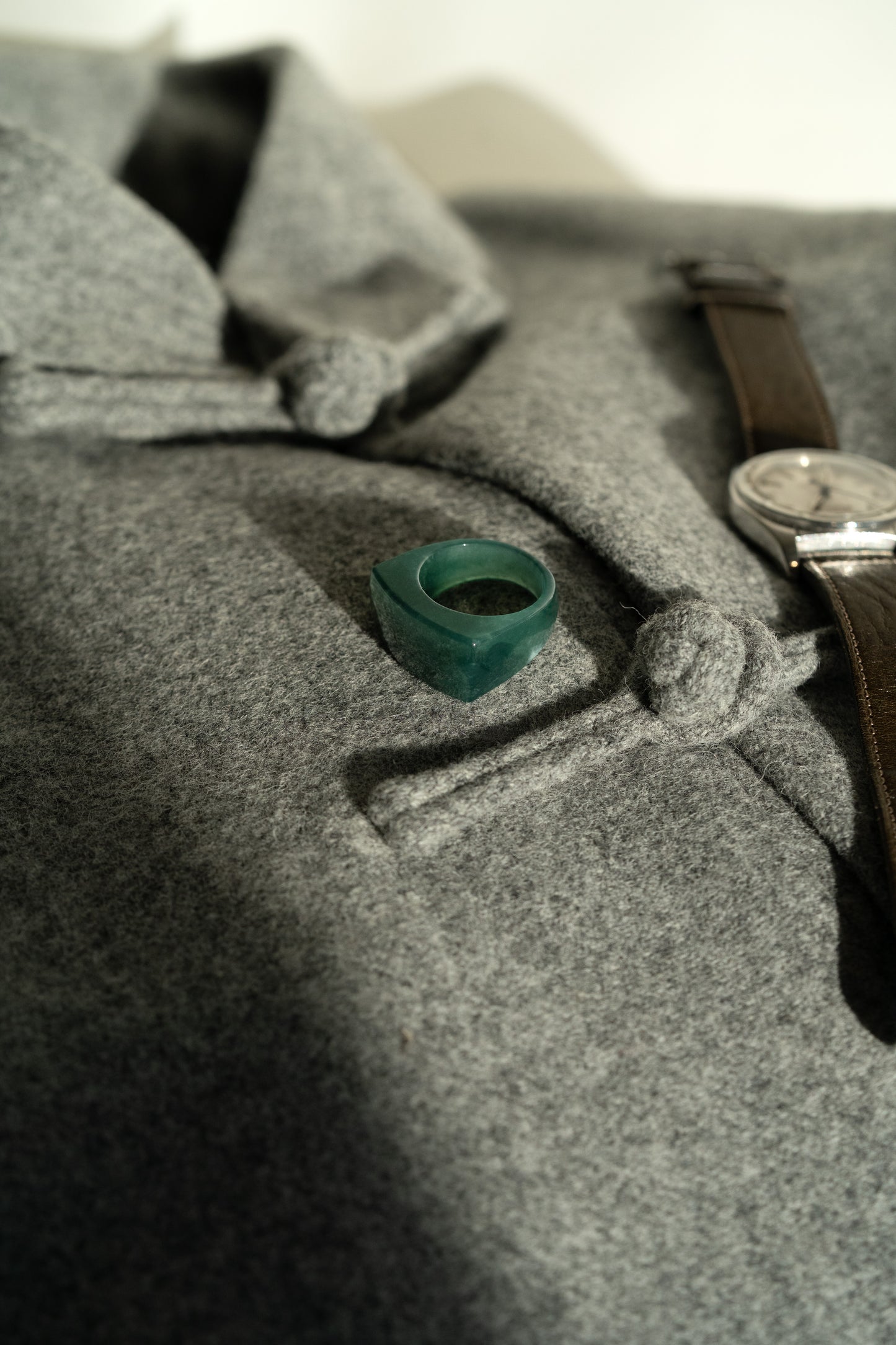 Intense Bluish Green Jadeite Ring with White Patches on Grey Wool Tang Jacket