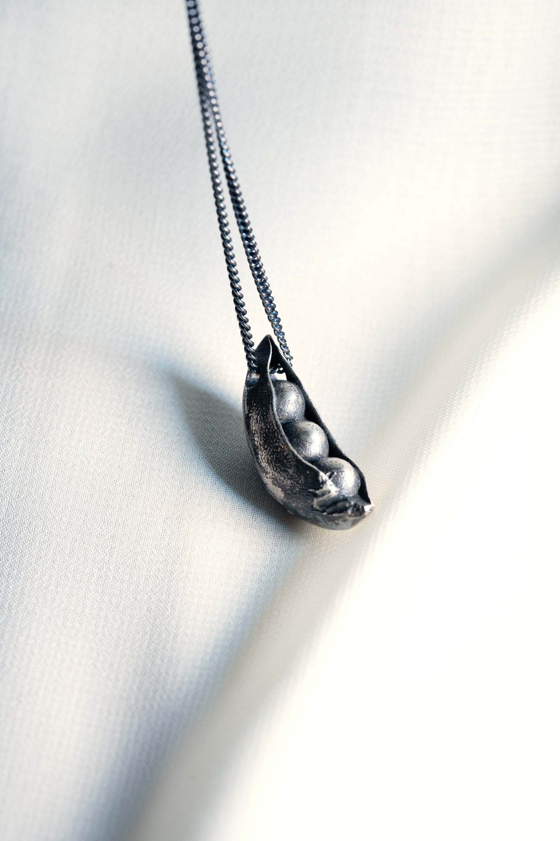 Sterling Silver Open Peapod Pendant hung on a Black 925 Sliver Chain