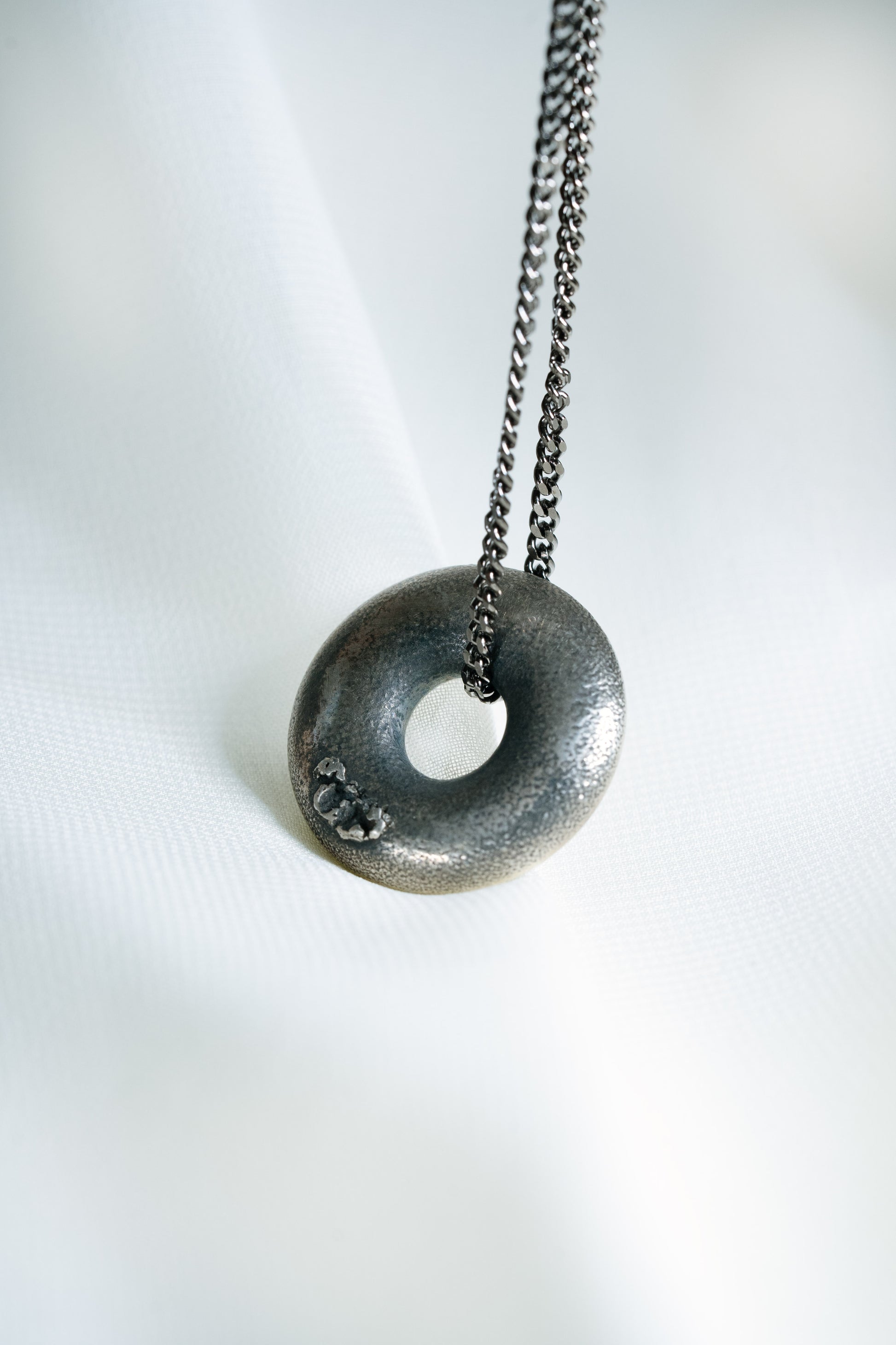 Sterling Silver Zen Doughnut Pendant hung on a Black 925 Silver Chain